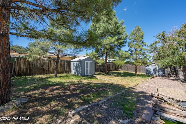 view of yard with an outbuilding, a storage shed, and a fenced backyard