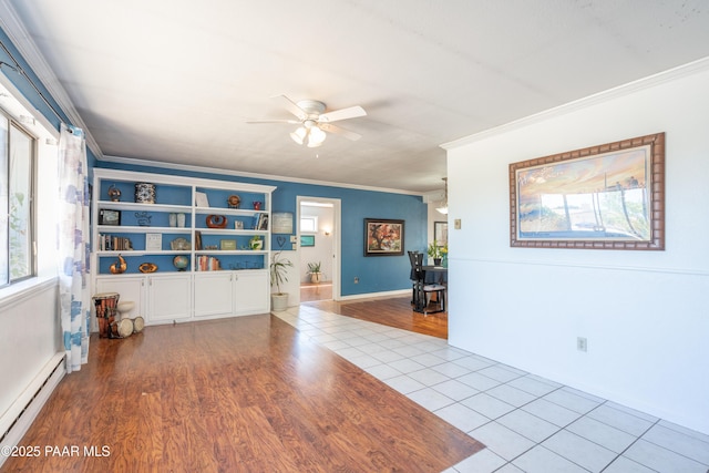 unfurnished room featuring a baseboard heating unit, wood finished floors, ornamental molding, and a ceiling fan