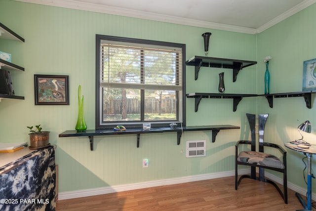 interior space with heating unit, baseboards, wood finished floors, and crown molding