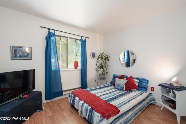 bedroom featuring a baseboard radiator and wood finished floors