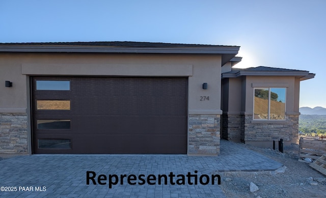 267 Looking Glass Dr, Prescott, AZ 86303 - view of front facade featuring stone siding, decorative driveway, stucco siding, a garage, and a mountain view
