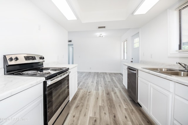 3924 N Taylor Dr, Prescott Valley, AZ 86314 - kitchen featuring stainless steel appliances, light wood finished floors, white cabinetry, and a tray ceiling