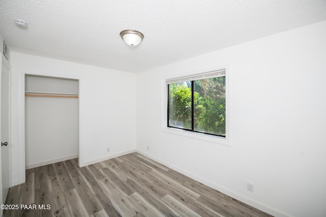 3924 N Taylor Dr, Prescott Valley, AZ 86314 - unfurnished bedroom featuring wood finished floors, a closet, and a textured ceiling