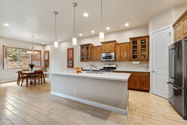 kitchen featuring visible vents, a sink, light countertops, appliances with stainless steel finishes, and brown cabinets