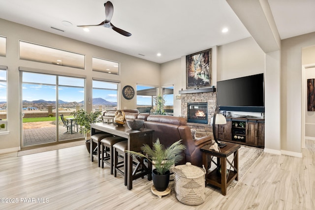 5242 High Cliff Way, Prescott, AZ 86301 - living room featuring ceiling fan, a stone fireplace, light wood-style floors, recessed lighting, and baseboards