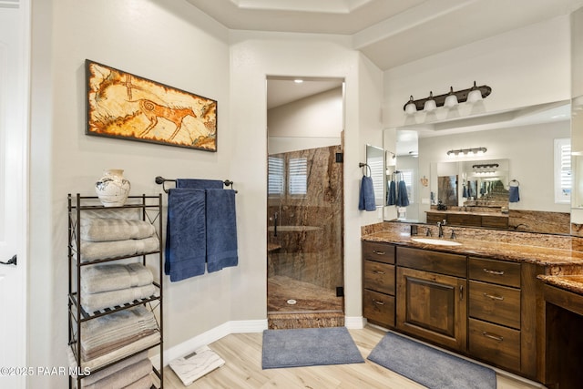 5242 High Cliff Way, Prescott, AZ 86301 - bathroom with a stall shower, vanity, wood finished floors, vaulted ceiling, and baseboards