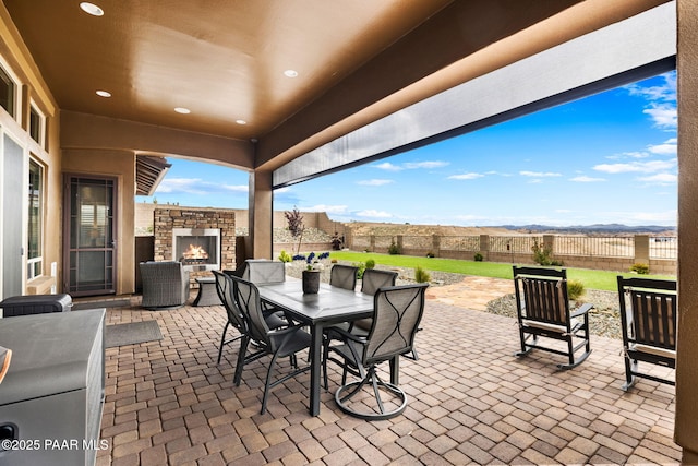 5242 High Cliff Way, Prescott, AZ 86301 - fenced backyard featuring an outdoor stone fireplace, a patio, outdoor dining area, and a mountain view
