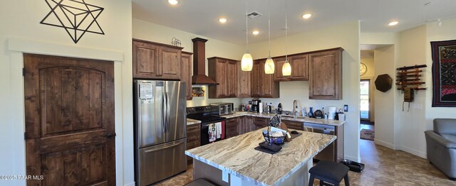 kitchen featuring hanging light fixtures, a breakfast bar, stainless steel appliances, a kitchen island, and a sink
