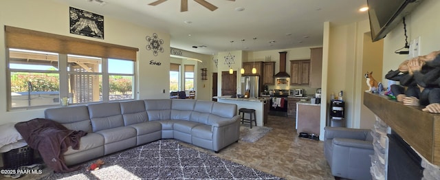 living area featuring a toaster, a ceiling fan, and visible vents