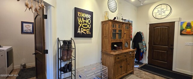 entrance foyer featuring separate washer and dryer, rail lighting, and baseboards