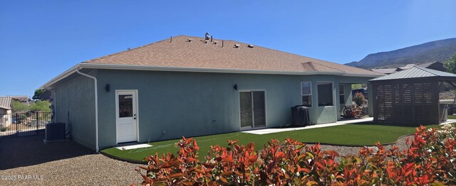 rear view of house featuring a mountain view, central AC, a gazebo, stucco siding, and fence