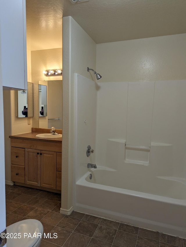 bathroom with bathtub / shower combination, vanity, and toilet