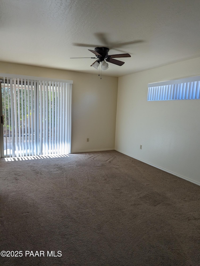 carpeted empty room featuring ceiling fan and a textured ceiling