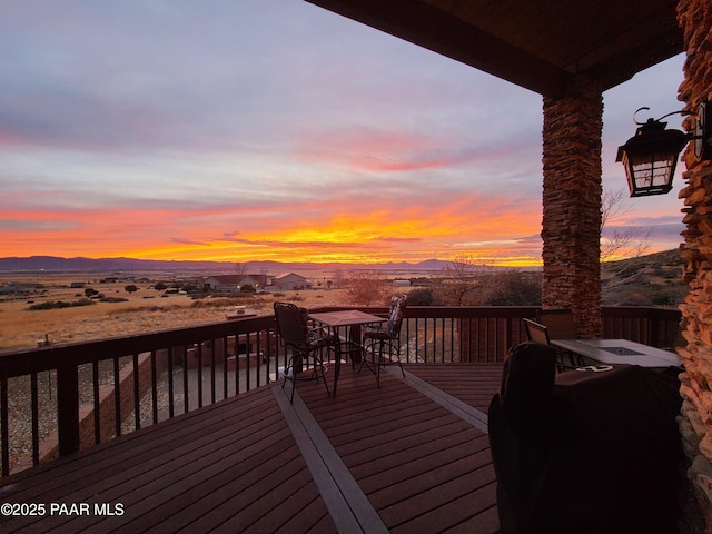 deck at dusk featuring a mountain view