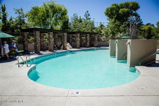 community pool featuring a patio area and fence