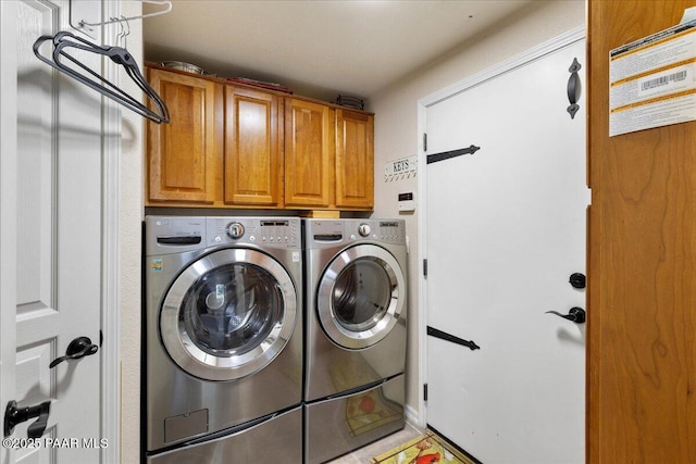 washroom with cabinet space and washer and dryer