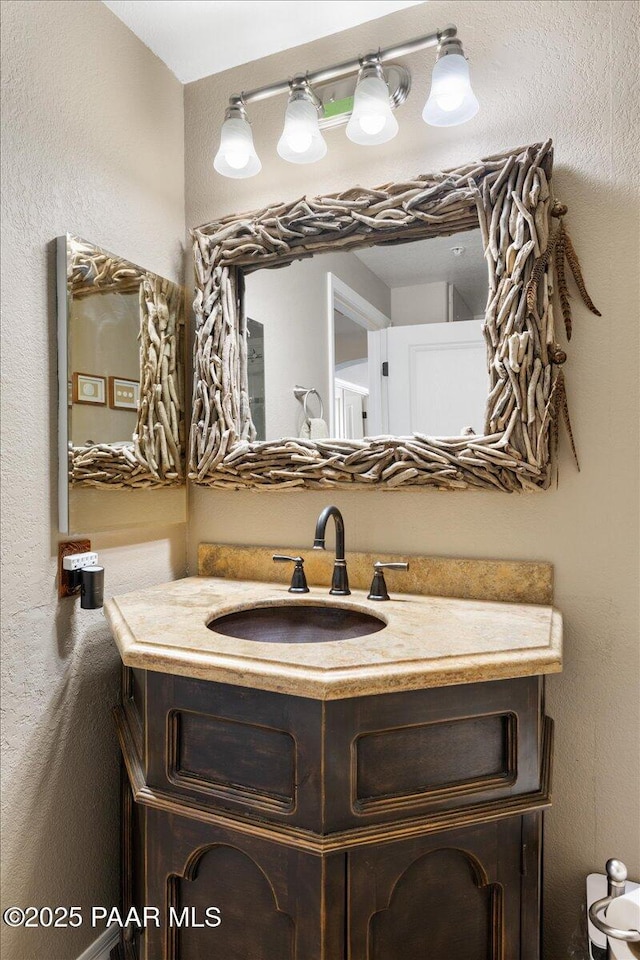 bathroom featuring a textured wall and vanity