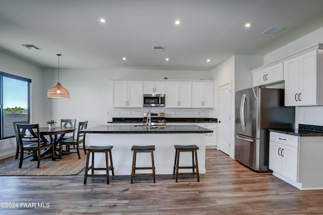 kitchen with appliances with stainless steel finishes, light wood-type flooring, white cabinetry, and sink