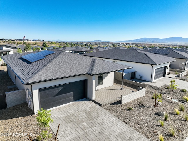 view of front of home featuring a mountain view, a garage, and solar panels