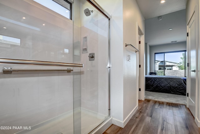 bathroom with a shower with shower door and wood-type flooring