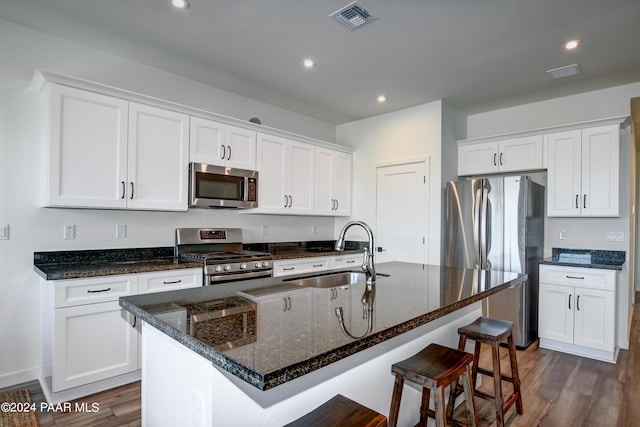 kitchen featuring stainless steel appliances, sink, a center island with sink, dark hardwood / wood-style floors, and white cabinetry