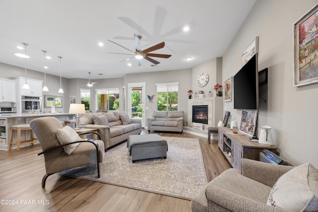 living room featuring light hardwood / wood-style floors and ceiling fan