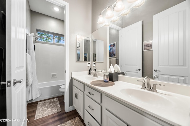 full bathroom with shower / tub combo, vanity, hardwood / wood-style flooring, and toilet