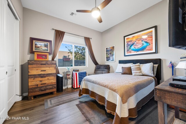 bedroom with ceiling fan, a closet, and hardwood / wood-style flooring