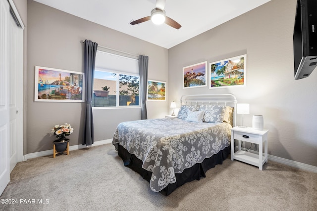 bedroom featuring a closet, light colored carpet, and ceiling fan