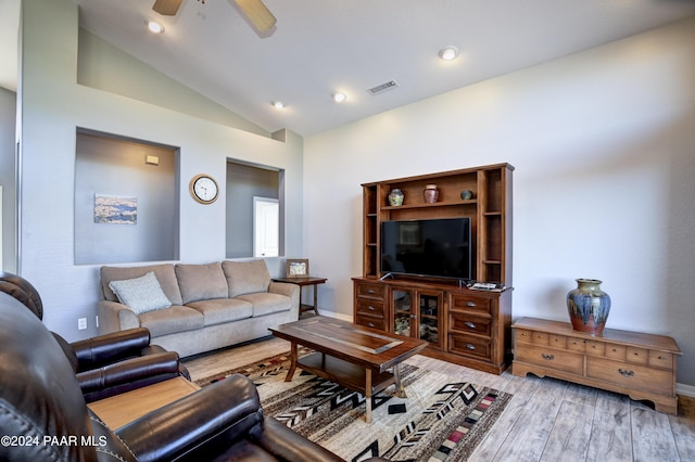 living room with ceiling fan, light hardwood / wood-style flooring, and vaulted ceiling