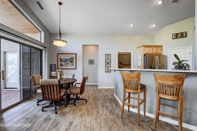 dining space featuring light hardwood / wood-style floors and lofted ceiling