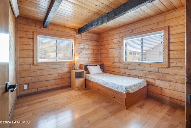 bedroom with beam ceiling, wooden walls, wood ceiling, and light wood-type flooring