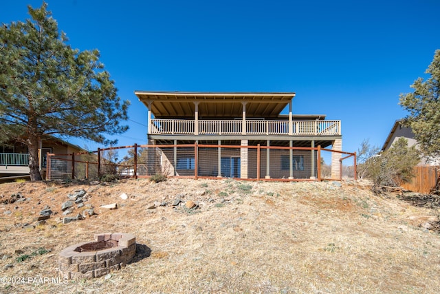 back of house featuring a deck and an outdoor fire pit