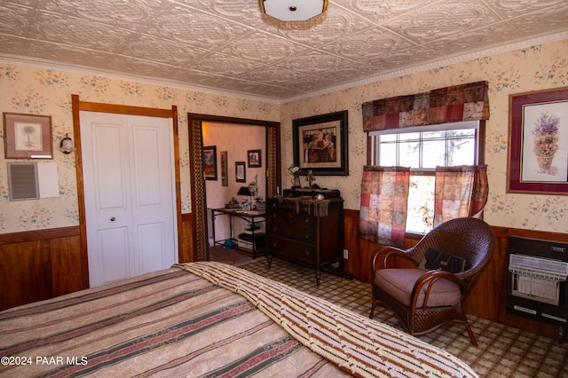 bedroom featuring heating unit, a closet, crown molding, and wood walls