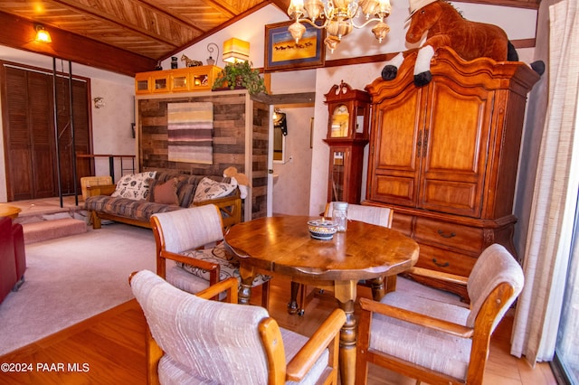 dining area featuring a notable chandelier, light wood-style flooring, light carpet, vaulted ceiling, and wooden ceiling