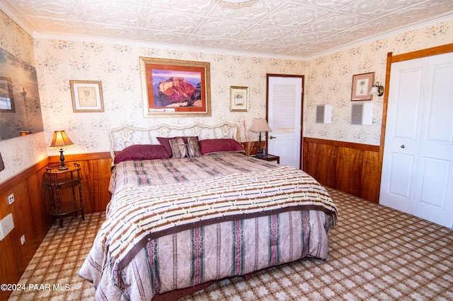 bedroom with wallpapered walls, an ornate ceiling, wood walls, and wainscoting