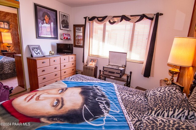 carpeted bedroom featuring wooden walls