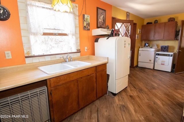 kitchen featuring wood finished floors, washer / clothes dryer, a sink, and a wealth of natural light