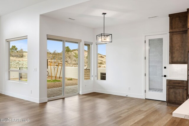 1148 S Lakeview Dr, Prescott, AZ 86301 - unfurnished dining area featuring a chandelier, baseboards, visible vents, and light wood-style flooring