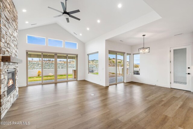 1148 S Lakeview Dr, Prescott, AZ 86301 - unfurnished living room featuring a healthy amount of sunlight, a fireplace, high vaulted ceiling, and wood finished floors