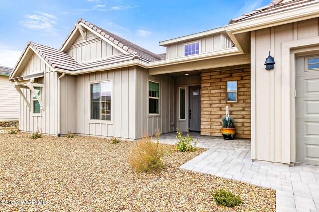1148 S Lakeview Dr, Prescott, AZ 86301 - view of exterior entry featuring stone siding, board and batten siding, an attached garage, and a tiled roof