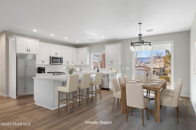 dining area featuring recessed lighting, visible vents, a notable chandelier, and wood finished floors