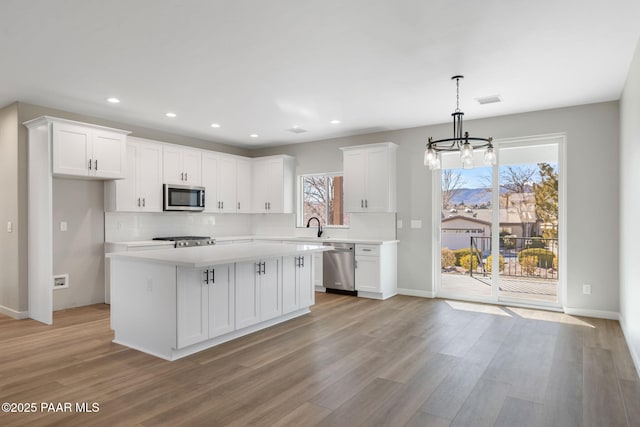 kitchen featuring a sink, light countertops, white cabinets, and stainless steel appliances