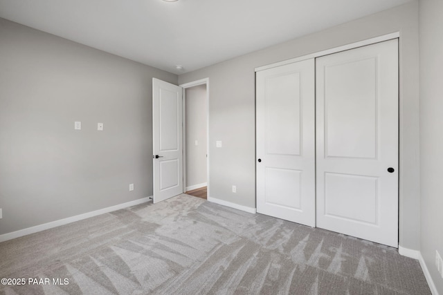 unfurnished bedroom with baseboards, a closet, and carpet floors