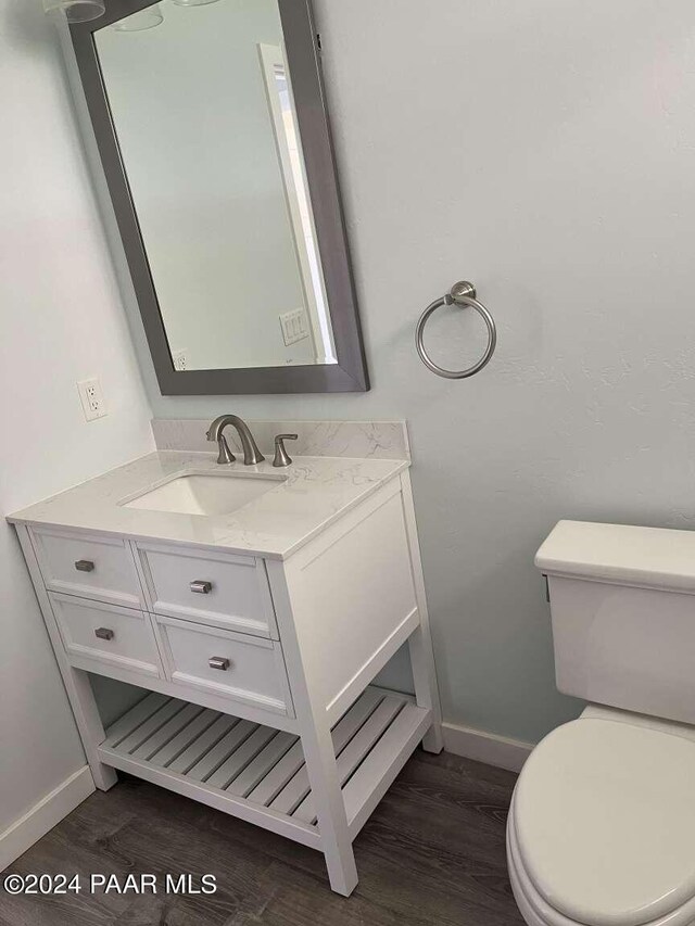 bathroom featuring vanity, hardwood / wood-style flooring, and toilet