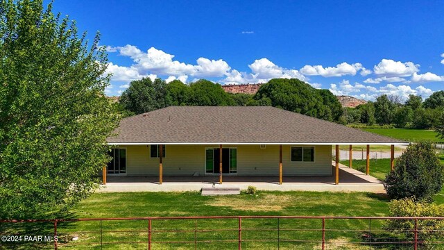 rear view of property with a lawn and a patio area