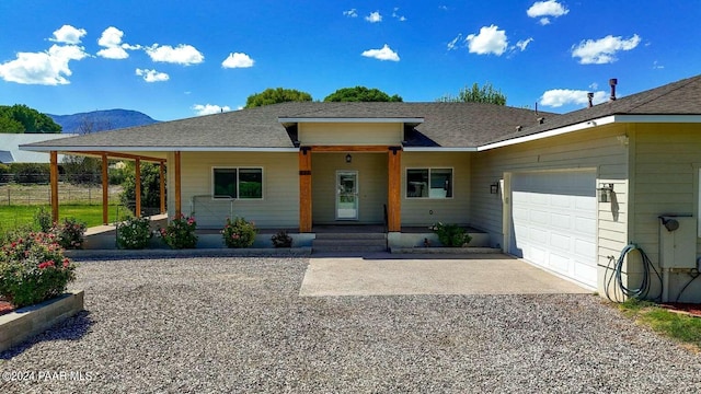 view of front of home featuring a mountain view, a porch, and a garage