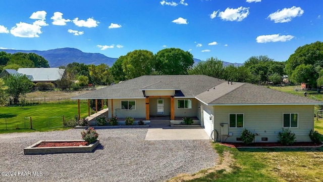 single story home with a mountain view, covered porch, and a front yard