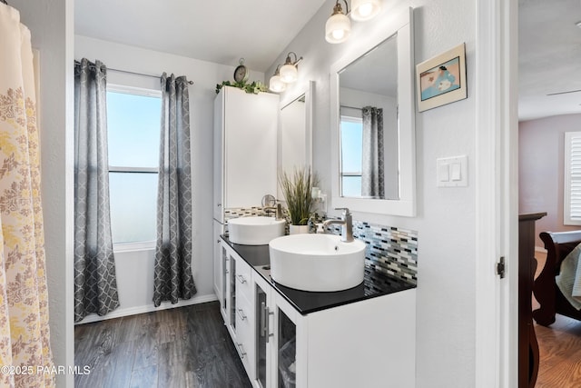 bathroom featuring vanity, backsplash, plenty of natural light, and hardwood / wood-style flooring