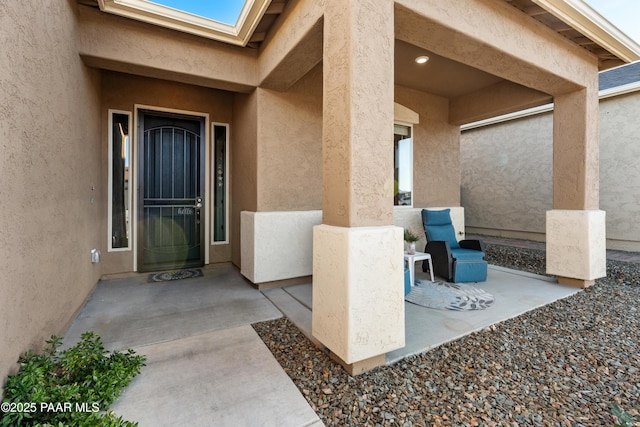 view of exterior entry with a patio